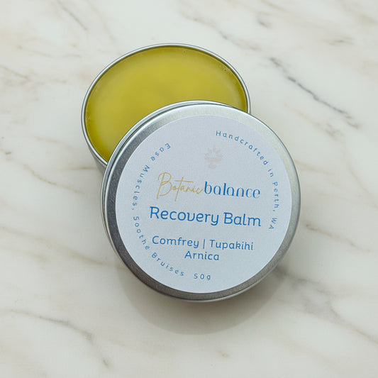Balm tin labeled 'Botanic Balance Recovery Balm' on a marble surface